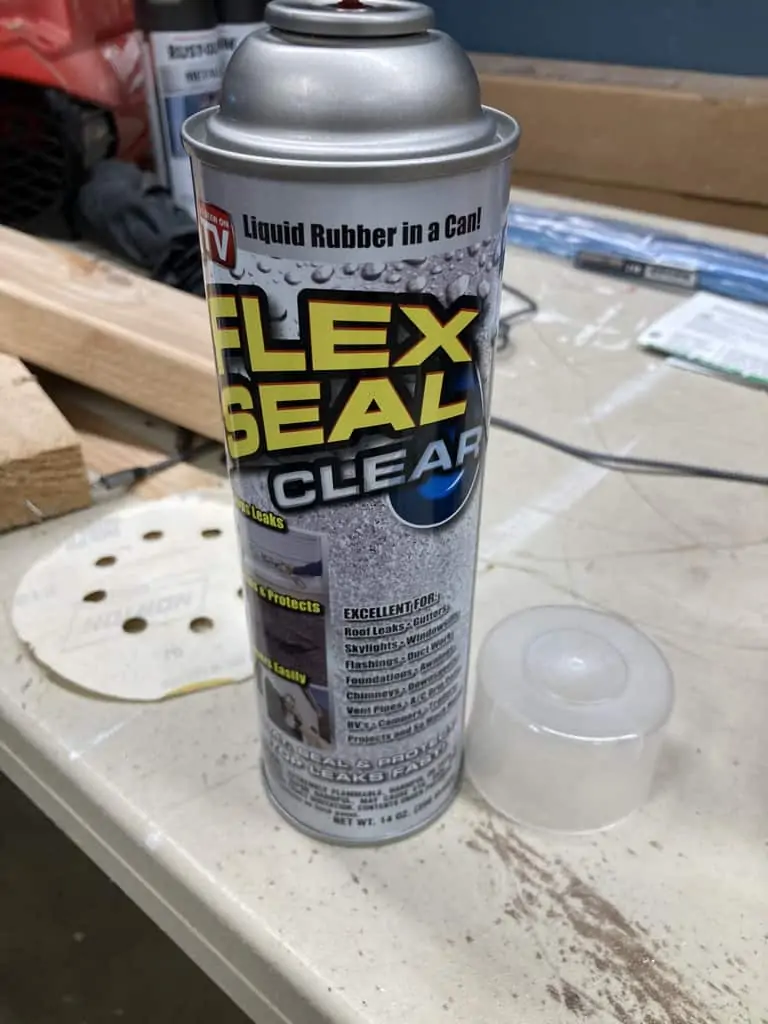 Applying flex seal to the feet of the ladder rail.