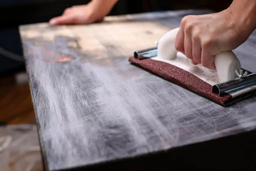 Sanding a table top to refinish it.