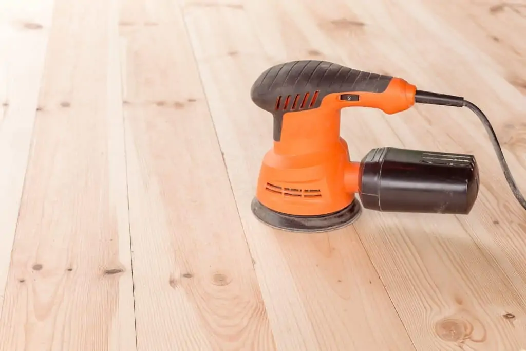 A corded sander on the floor.