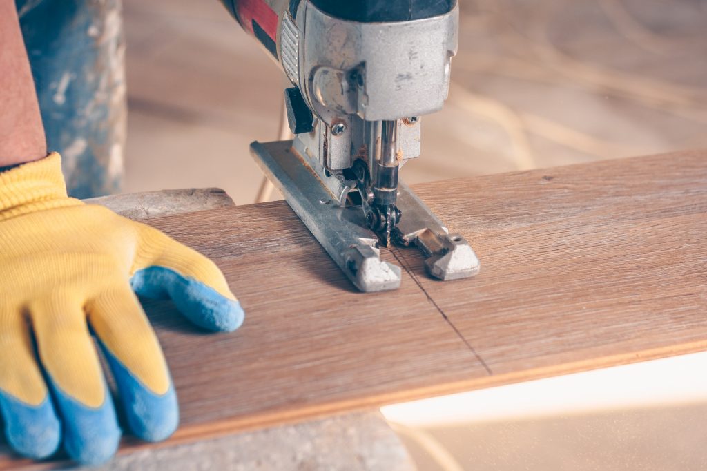 A jigsaw cutting flooring.