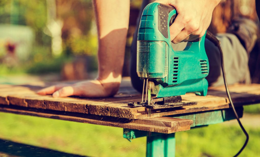 A jigsaw cutting outdoors.